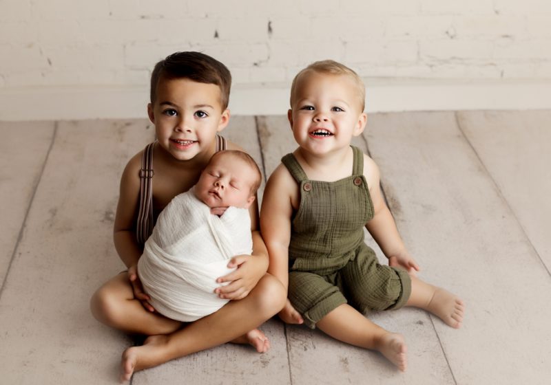 cute brothers with newborn baby