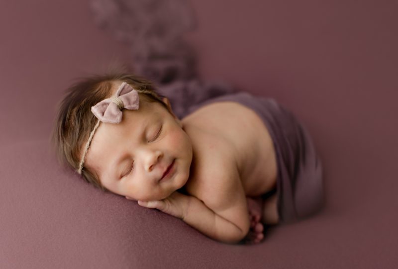 newborn girl on purple 