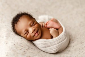 newborn photographer, a little baby is swaddled in blankets and comfy
