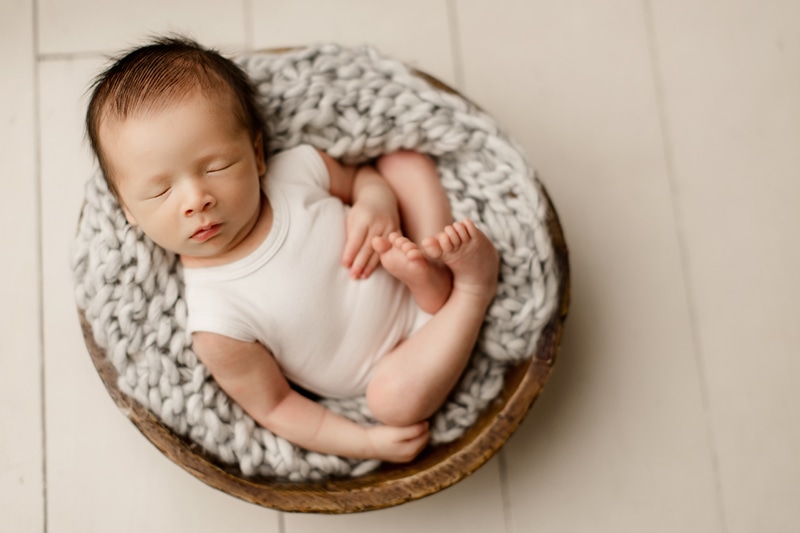 Newborn Photographer, a baby is sound asleep in a little basket