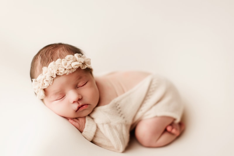 Newborn photographer, a baby sleeps cuddled in a blanket