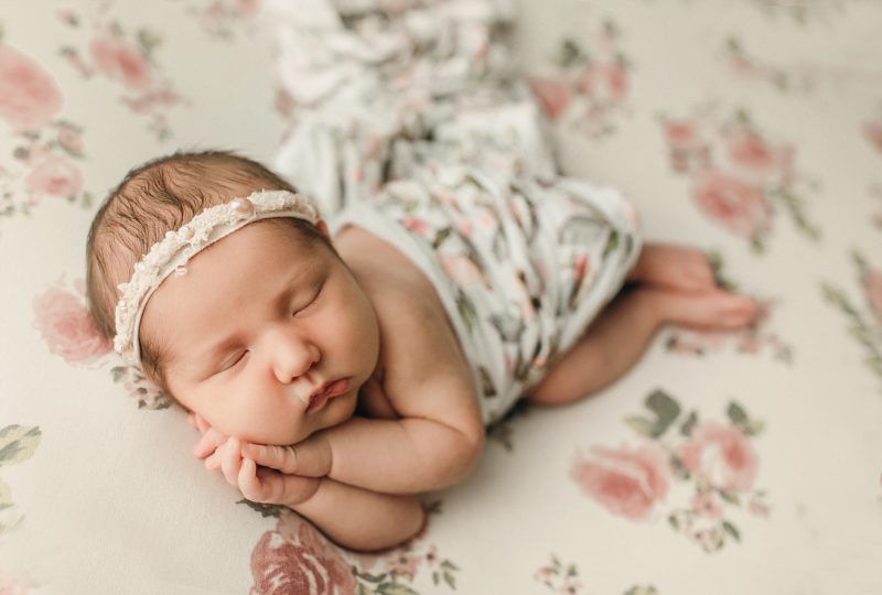baby wrapped in floral swaddle