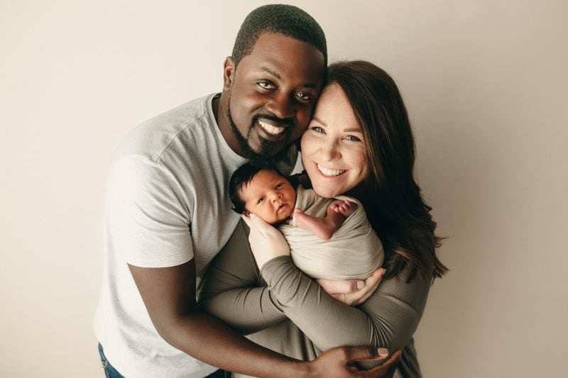 mom and dad holding newborn baby family portrait