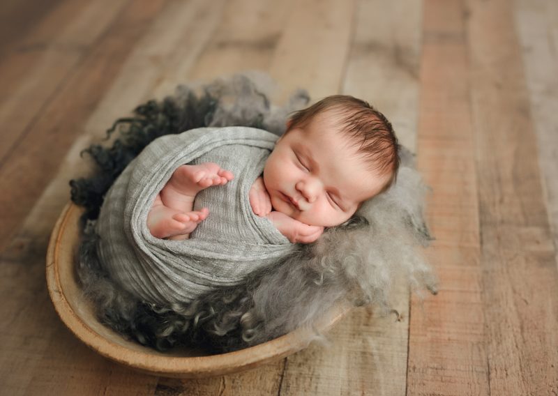 newborn boy swaddled in gray in wood bowl, mckinney newborn photographer