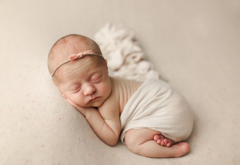 newborn swaddled in white laying on tummy, dallas newborn photos baby zoe