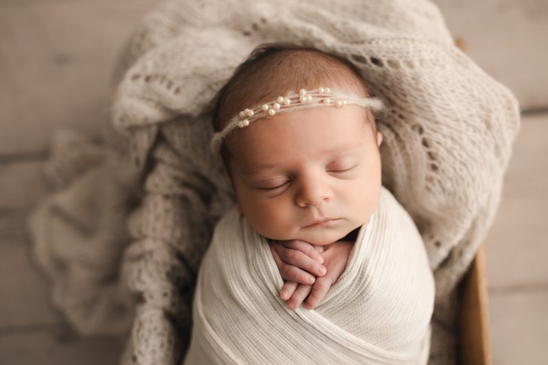 newborn girl swaddled in white with pearl headband, frisco newborn photo session baby livia