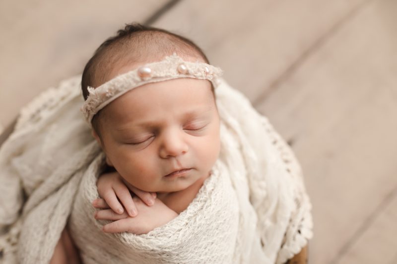 newborn swaddled in white with hands under chin, frisco newborn photo session baby livia