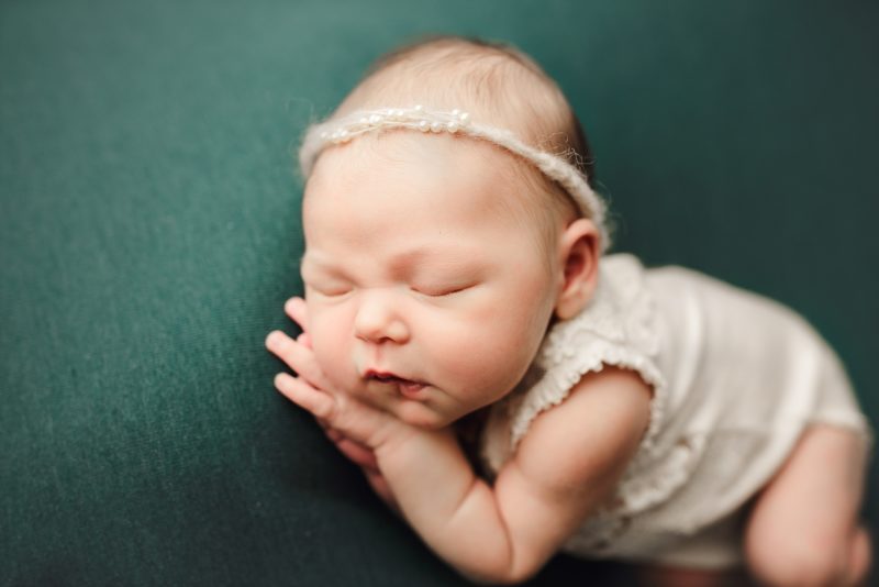 newborn sleeping on hands on green blanket, dallas newborn photo session baby mavis