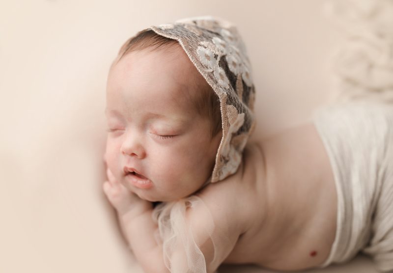 newborn sleeping wearing lace bonnet