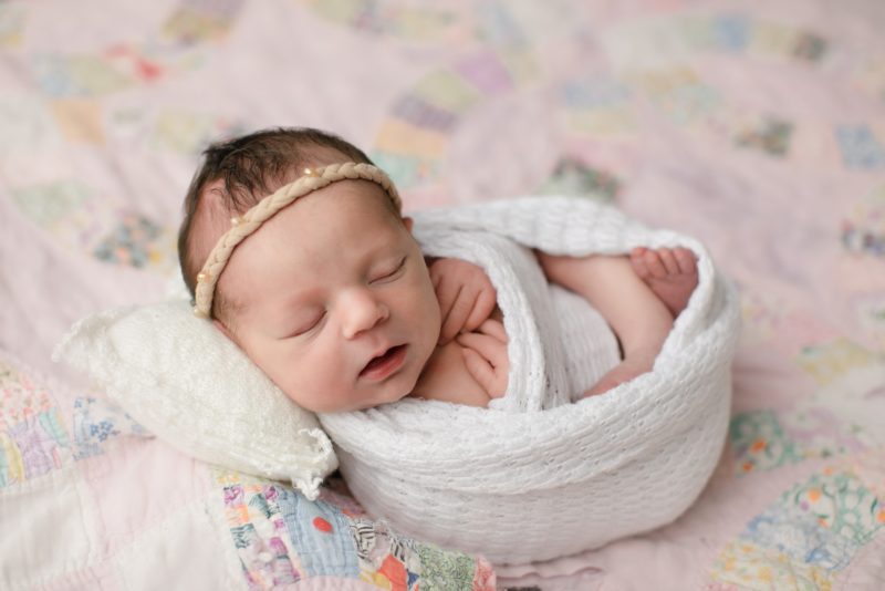 newborn swaddled in white on pink quilt, dallas newborn photography session baby giuliana