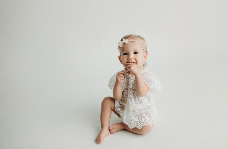 baby wearing white outfit on white background