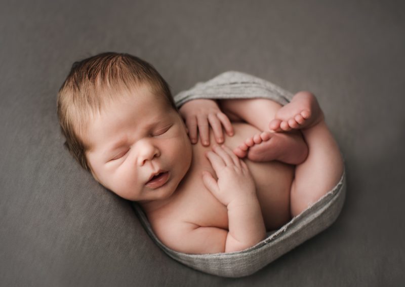 newborn swaddled in gray on gray blanket, mckinney newborn photography session baby camden