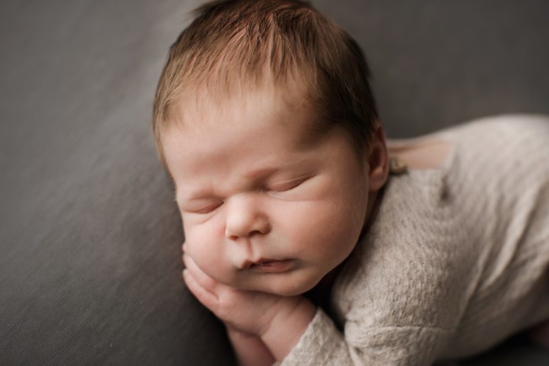 newborn sleeping on hands on gray blanket, mckinney newborn photography session baby camden