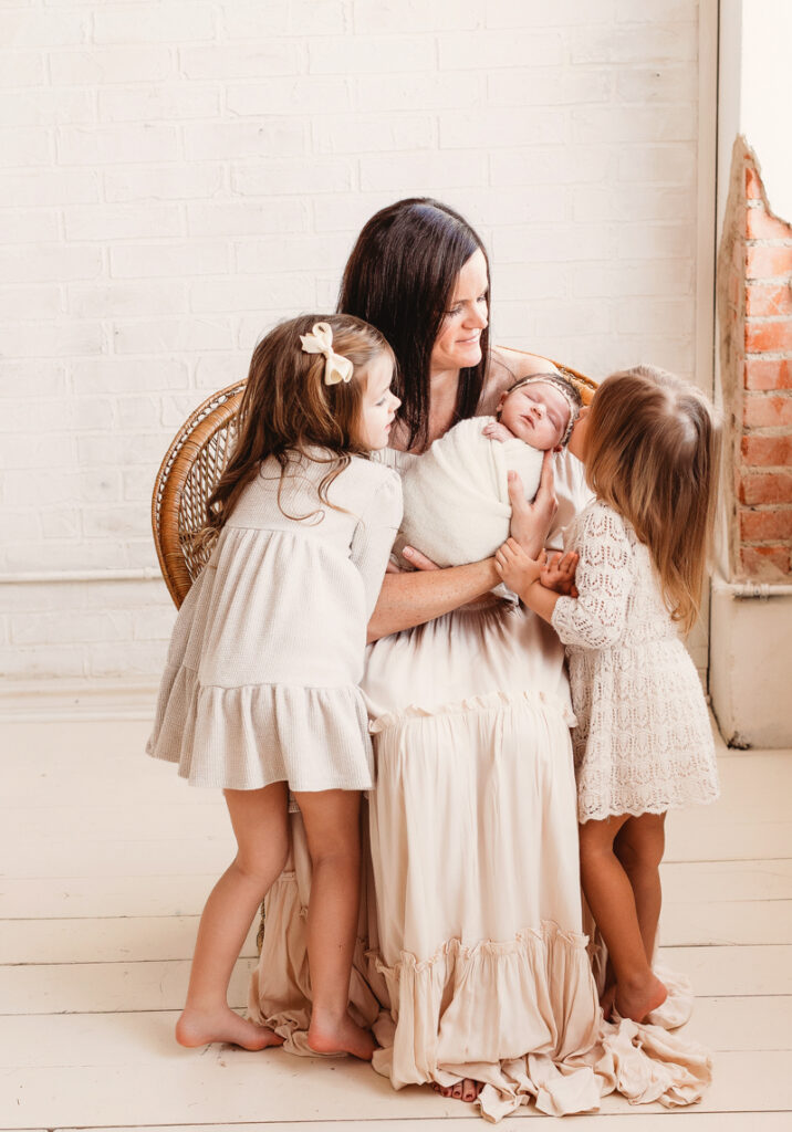 mom and three daughters during newborn photography session